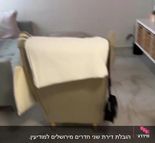 כורסה עם שמיכה לבנה על רצפת שיש
